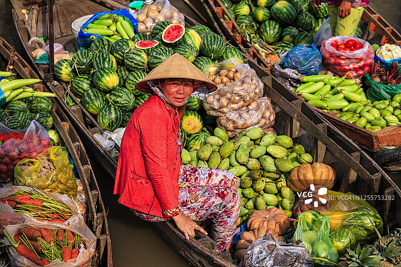 在越南湄公河三角洲水上市场卖水果的越南妇女图片素材