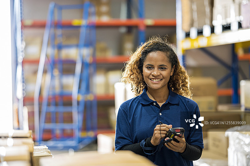 非洲女仓库管理员手持条形码扫描器正面照图片素材