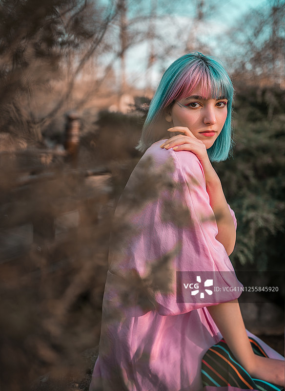 染着蓝色和粉色头发，穿着粉色连衣裙的少女肖像图片素材