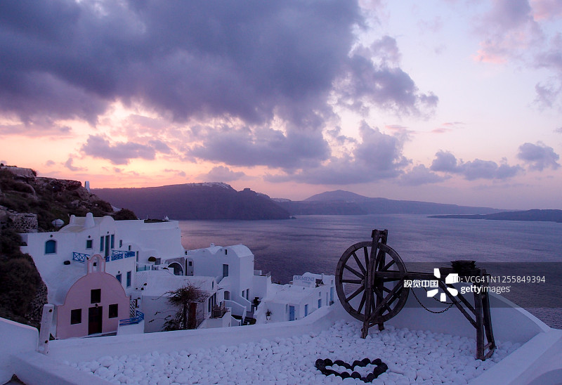 圣托里尼伊亚白色屋顶上的旧木轮图片素材