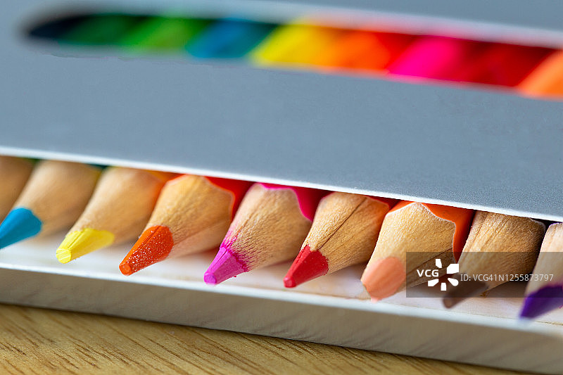 纸盒装彩色铅笔，彩虹色，橙色铅笔特写，学校或办公用品图片素材