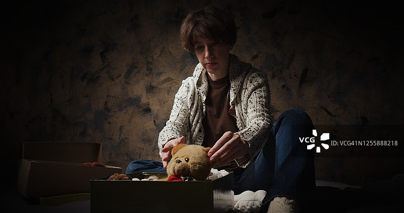 女人将毛绒玩具装入盒子图片素材