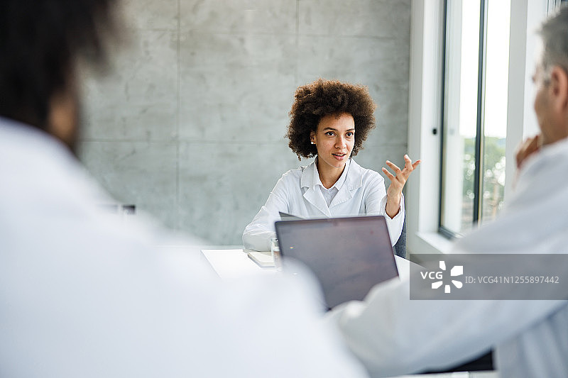非裔美国医生在会议上与同事交谈图片素材