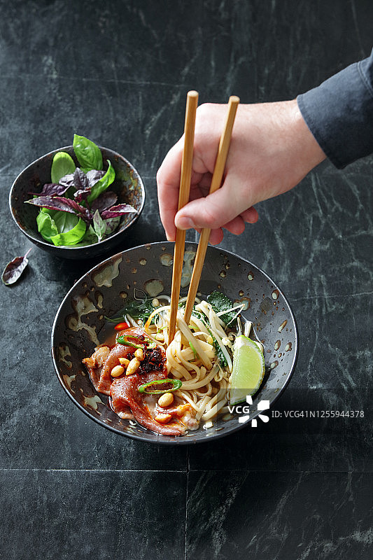 成年男子吃正宗的河粉牛肉面。越南的传统食品图片素材