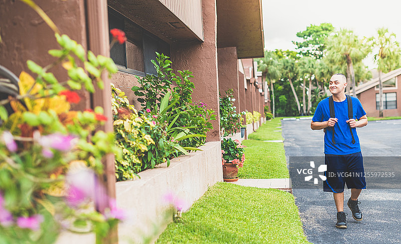 背着背包的年轻人在居民区行走图片素材