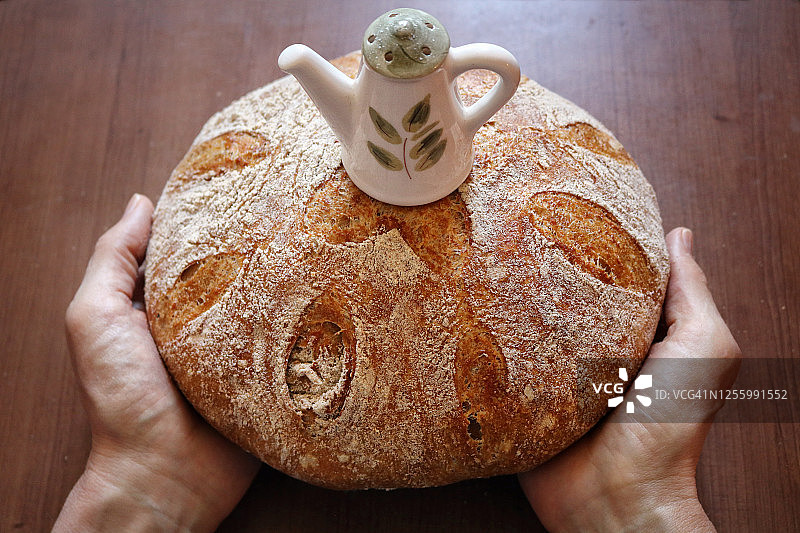 手捧荷兰烤箱免揉全麦面包图片素材
