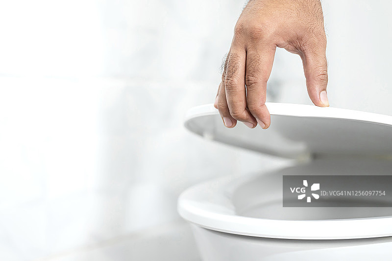 男人在浴室用手打开马桶座圈图片素材