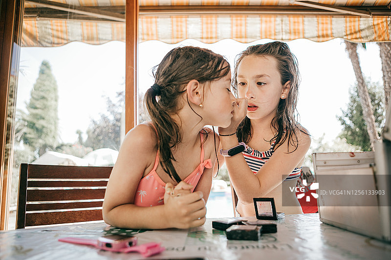 夏天在家玩化妆玩具的两个女孩图片素材