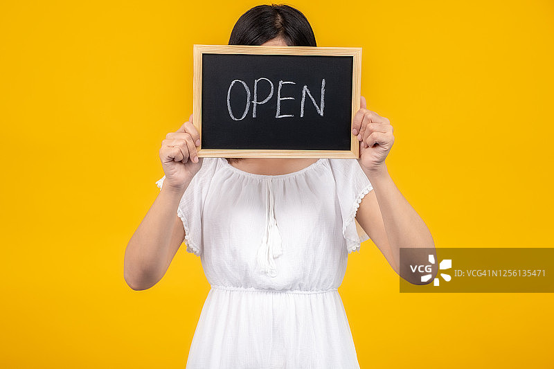 疫情隔离后，小企业主微笑 держа в руках重新开业标志图片素材