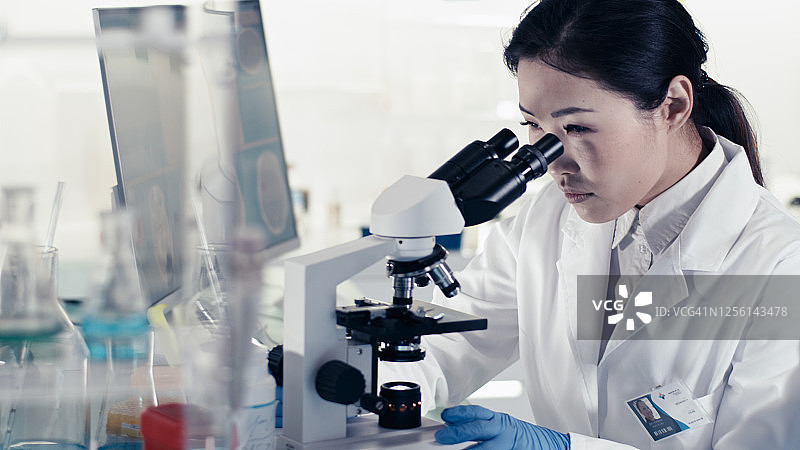 遗传研究实验室内部，亚洲女医生使用显微镜图片素材