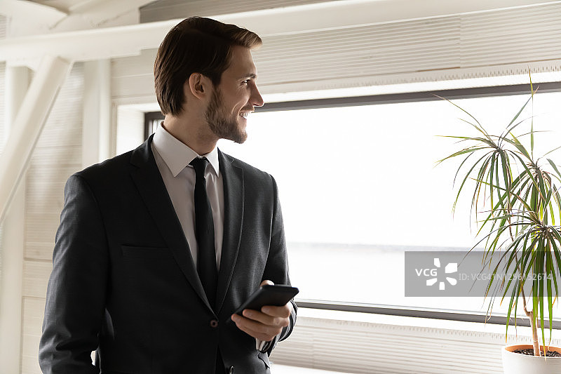 面带微笑的年轻商人眺望远方，若有所思图片素材