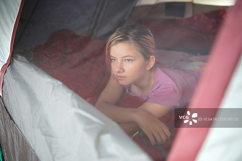 在帐篷里的女孩向窗外看图片素材