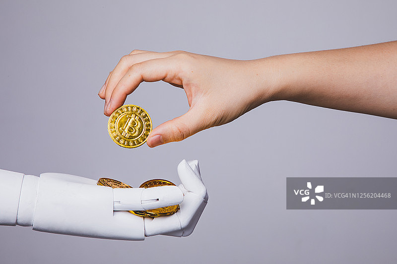 人手从机械手中拿走比特币图片素材