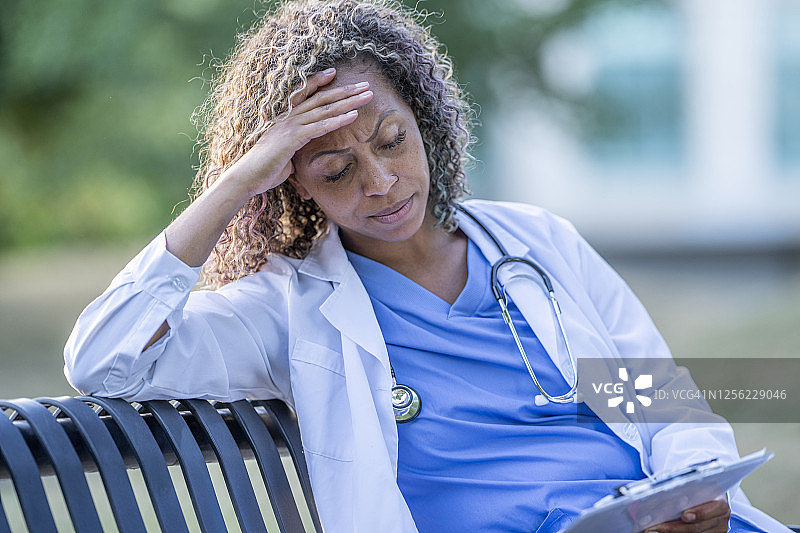 坐在外面查看病人图表的非裔美国医生图片素材