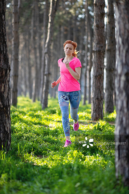 中年妇女在树林里慢跑图片素材