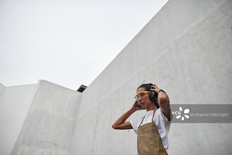 戴着个人防护装备的亚洲女木匠准备工作图片素材