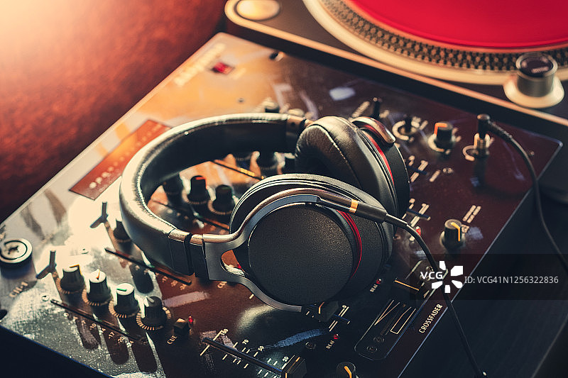 DJ耳机在混音器和乙烯基背景上图片素材
