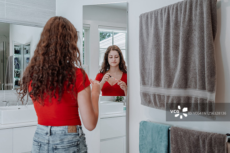 年轻女人照镜子涂口红图片素材