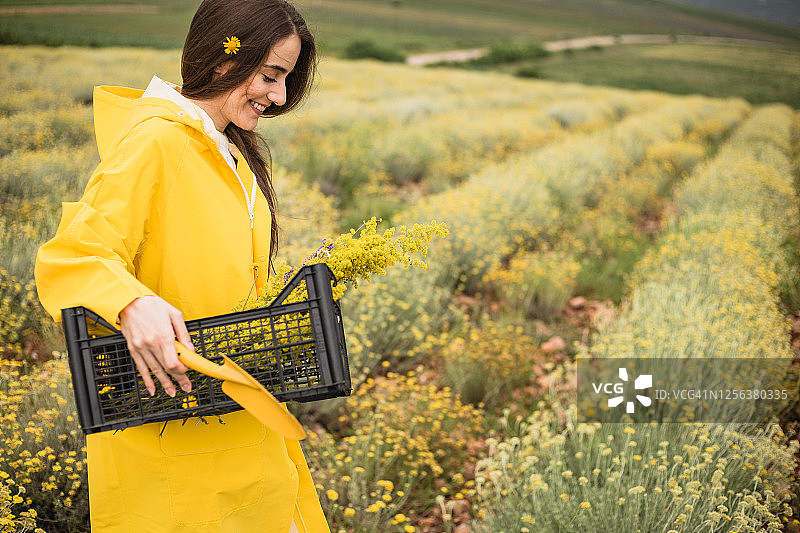 农场女工 carrying 篮子，里面装着她刚收割的草药图片素材