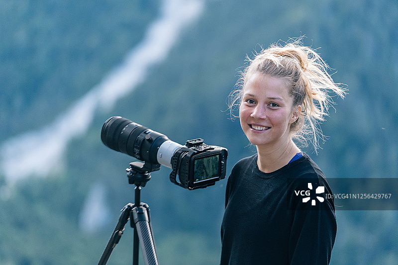 年轻女摄影师对着镜头微笑图片素材