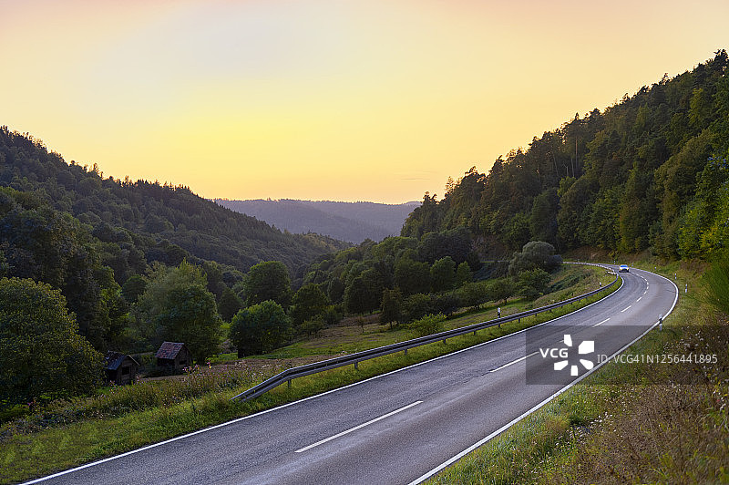 日落时分乡村公路上的汽车图片素材