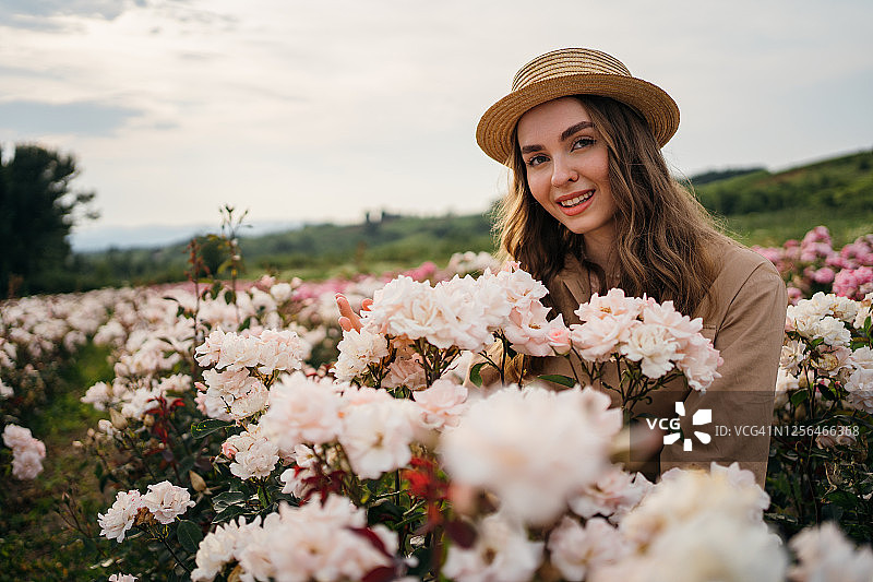 在玫瑰花田中微笑的女人肖像图片素材