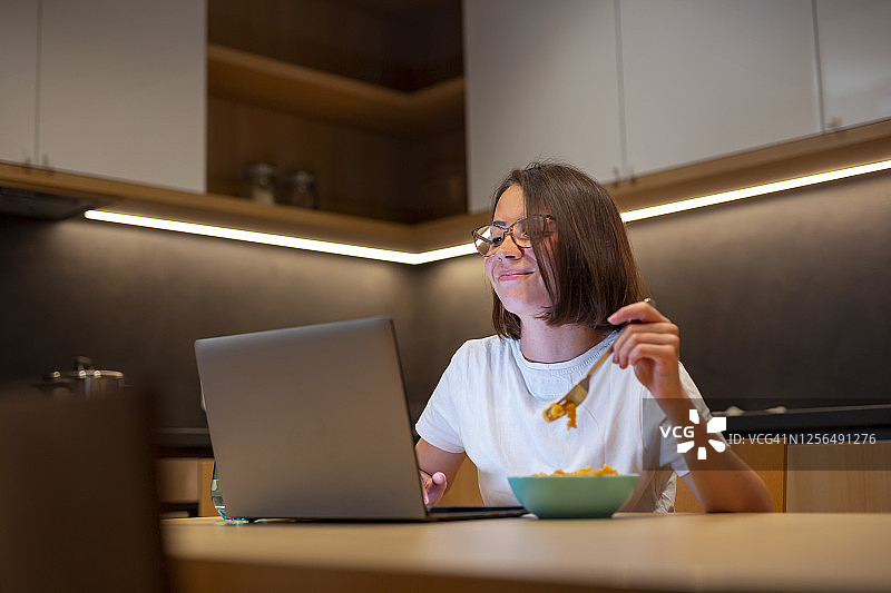 女人一边吃晚餐一边看电影图片素材