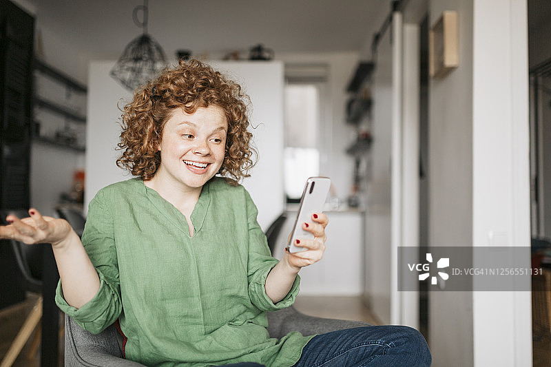笑容甜美的女人在家使用智能手机的特写图片素材