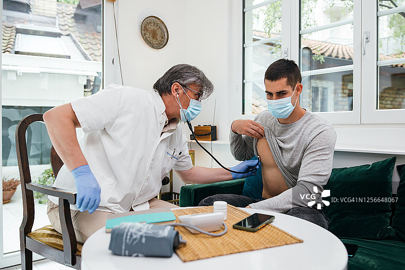医生上门拜访一位年轻人图片素材
