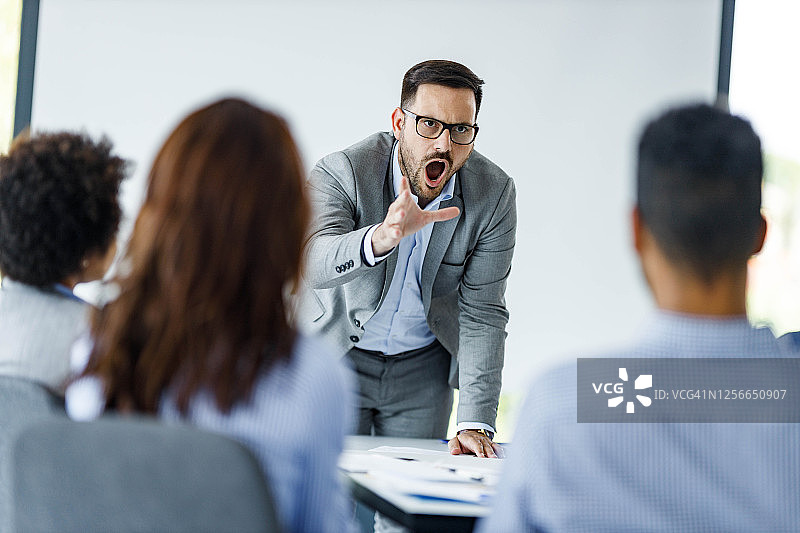 愤怒的CEO在办公室的演示文稿中与同事争论。图片素材