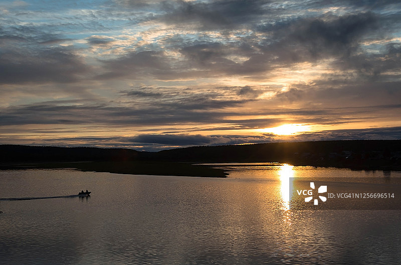 美丽日落时分宽阔河流上的渔船图片素材