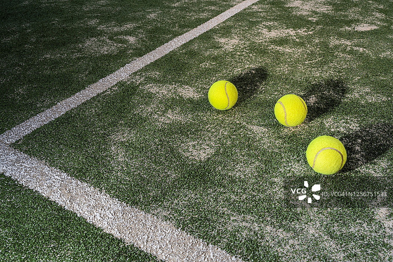 绿色桨式网球场上的三个球图片素材