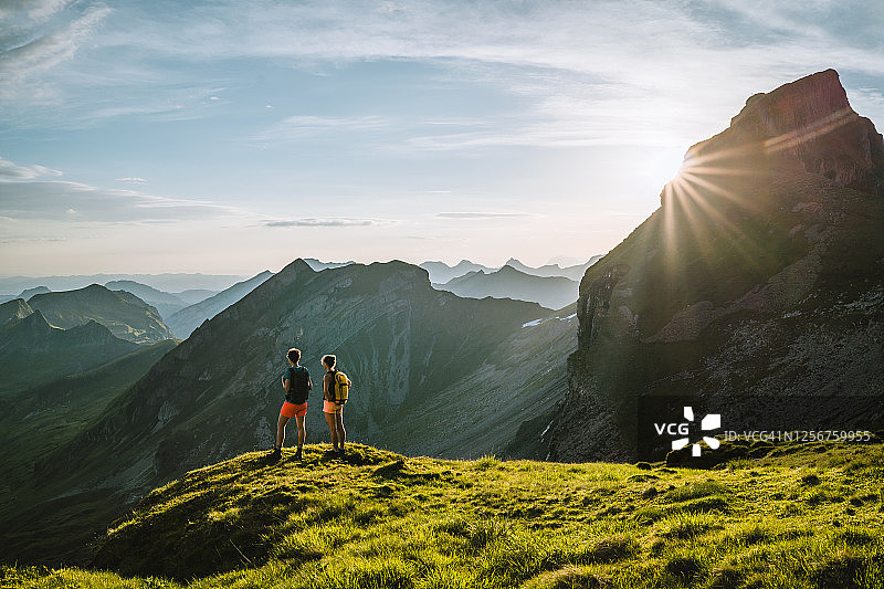 越野跑者在高山山脊顶峰眺望图片素材