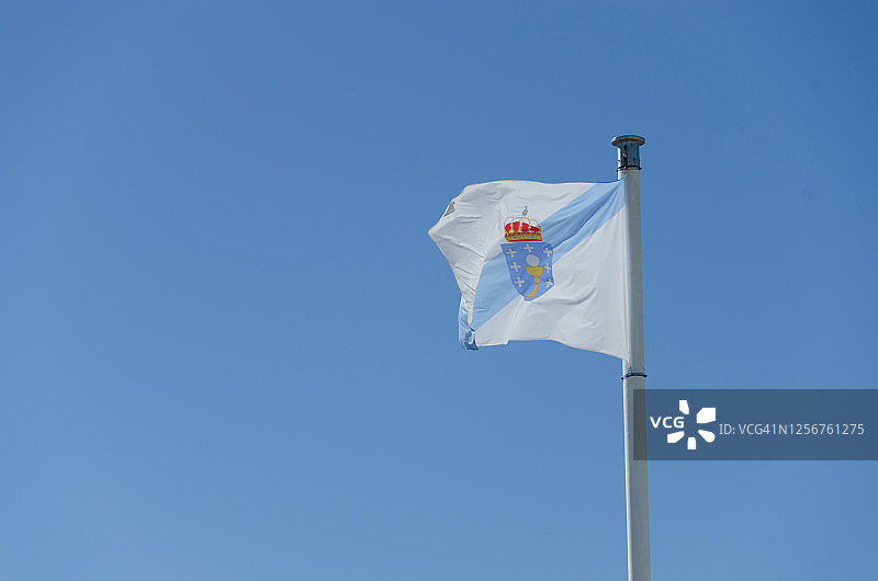 加利西亚旗帜在晴朗的天空下飘扬图片素材