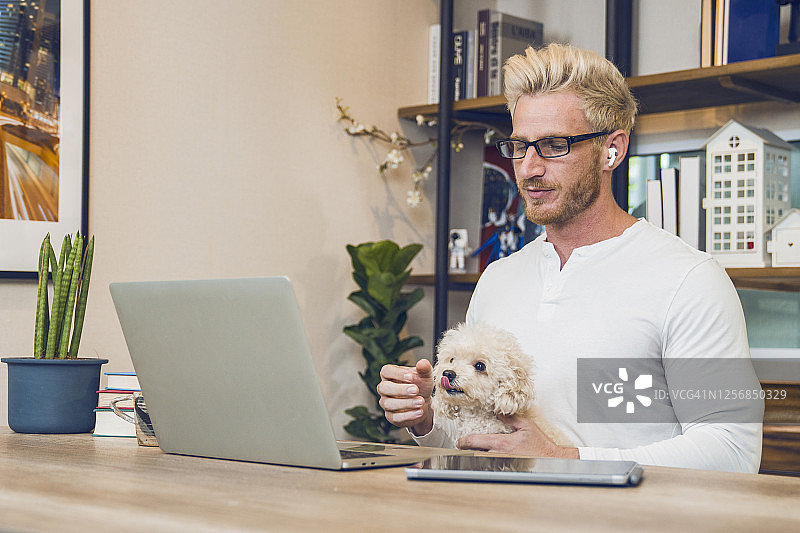 在家与猫狗一起工作的男人图片素材