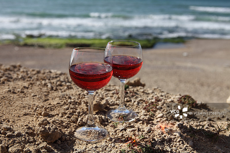 沙滩上的玫瑰红酒杯和海浪图片素材