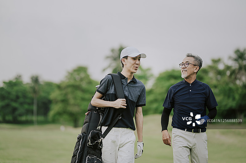 中国老年高尔夫球手在马六甲高尔夫球场上与儿子交谈图片素材