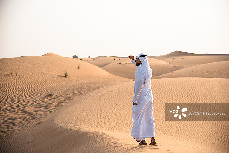 在沙漠中行走的阿拉伯男人图片素材