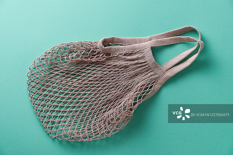 可重复使用的环保购物袋，由可回收材料制成的网兜，绿色背景图片素材