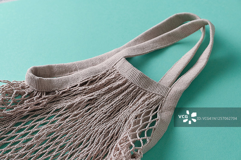 可重复使用的环保购物袋，由可回收材料制成的网兜，绿色背景图片素材