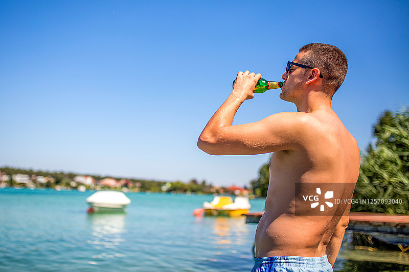 年轻男人享受冰镇啤酒图片素材