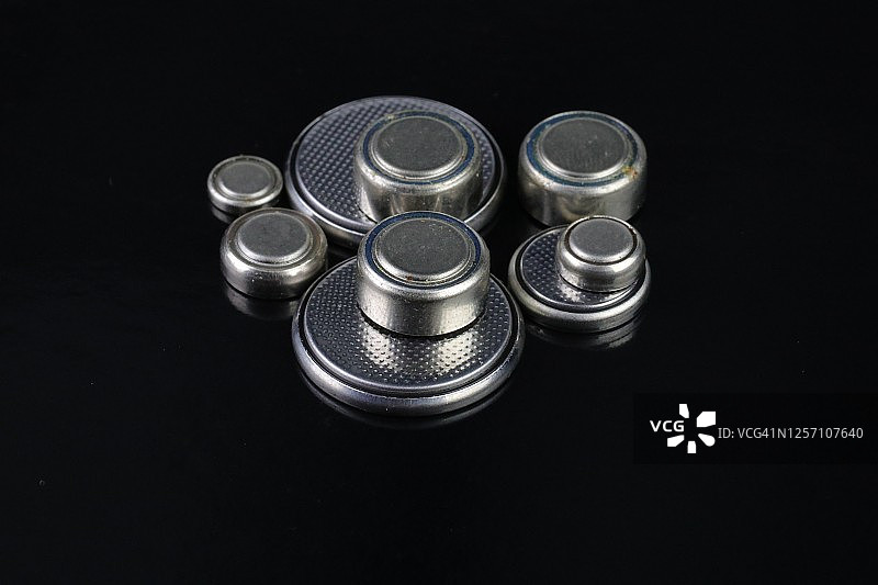 黑色背景上的纽扣电池图片素材
