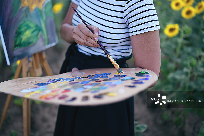 年轻女人在户外画向日葵图片素材
