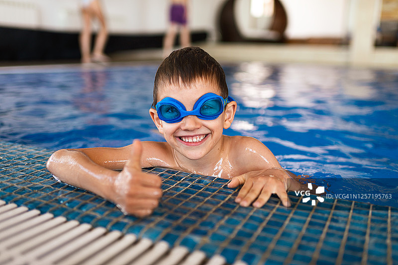 游泳池里满意的男孩图片素材