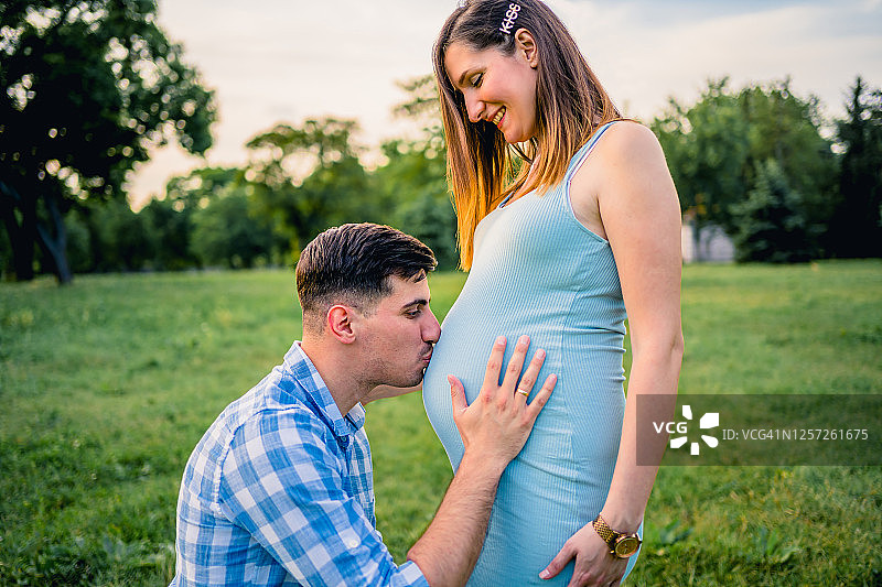 男人亲吻怀孕妻子的肚子图片素材