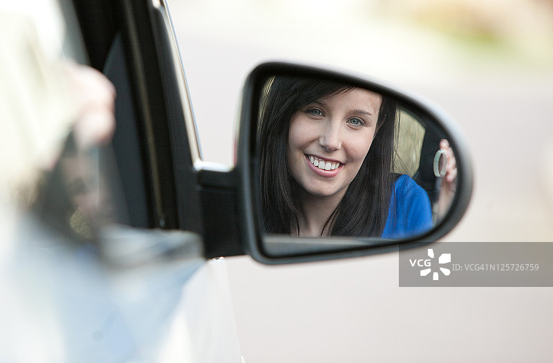 坐在车里拿着钥匙的迷人少女图片素材