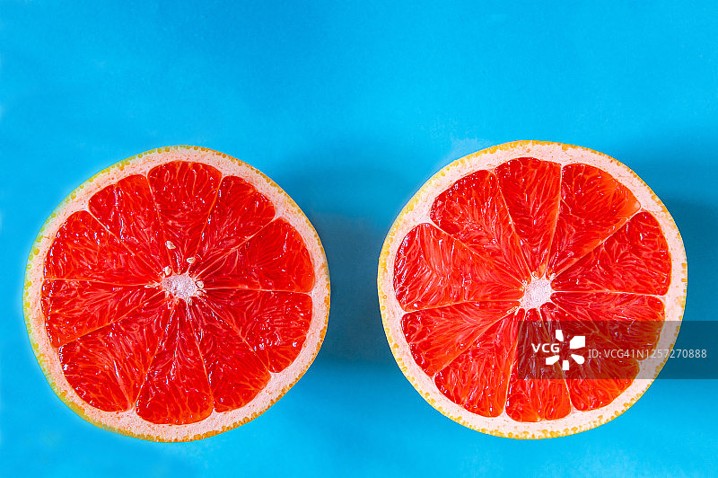 蓝色背景上的红色西柚切片图片素材