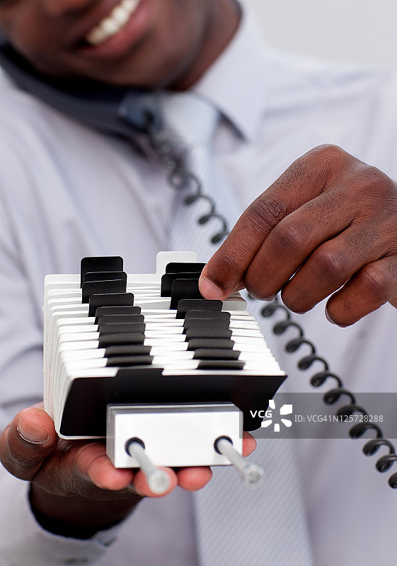 打电话并看着索引夹的商人图片素材