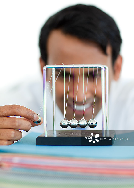 年轻商人玩动能球图片素材