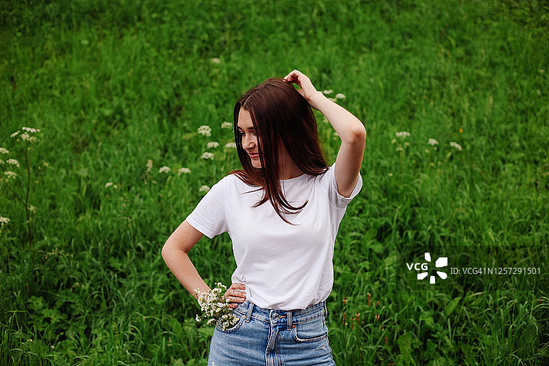 街头夏日写真：黑长发年轻女子身穿蓝色裙子和白色T恤，夏季时尚生活方式概念图片素材